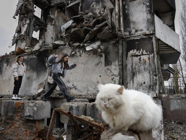 Girls pass a destroyed building in Borodyanka, Ukraine. Picture: Getty Images