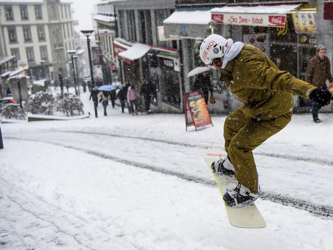 Sylvain rides his snowboard on a snow-covered street in Lausanne, Switzerland, Thursday, March 1, 2018. Persistent snow and freezing conditions from a Siberian cold snap caused a handful of deaths across a swathe of Europe from Britain to the Balkans. Picture: AP