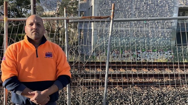 Mr Fitzgerald’s business backs on to the train line – where graffiti can be seen at a nearby apartment block. Picture: Matt Gazy