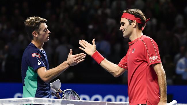 Swiss Roger Federer (R) shakes hands to Australian Alex de Minaur after winning at the Swiss Indoors tennis tournament in Basel on October 27, 2019. (Photo by FABRICE COFFRINI / AFP)