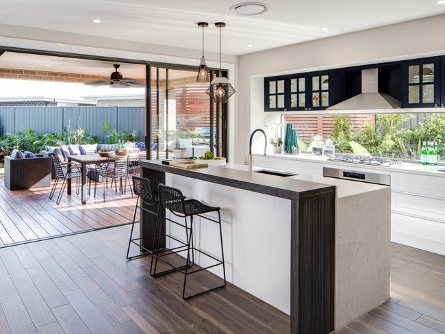 A glass splashback and large sliding doors give the open-plan living space a strong connection to the garden.