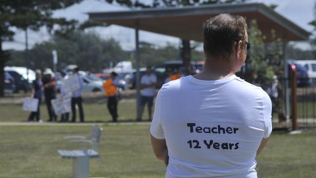 More than 200 people converged on Coffs Harbour Jetty to protest the NSW government's vaccine mandate. Many wore white T-shirts with their profession and length of service on the back. Picture: Tim Jarrett