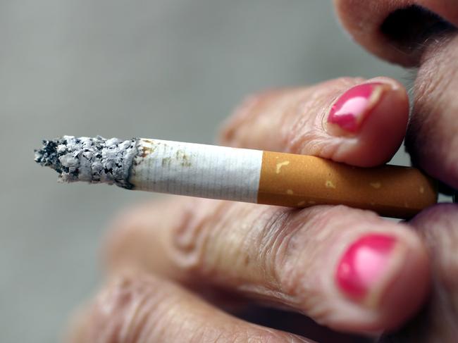 Hands and mouth of woman smoker with cigarette.