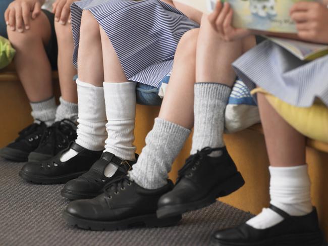 Low section of elementary students sitting in row in classroom