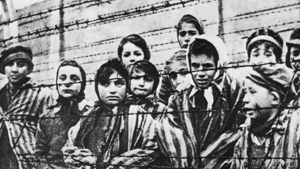 Children behind the barbed wire of Auschwitz concentration camp.