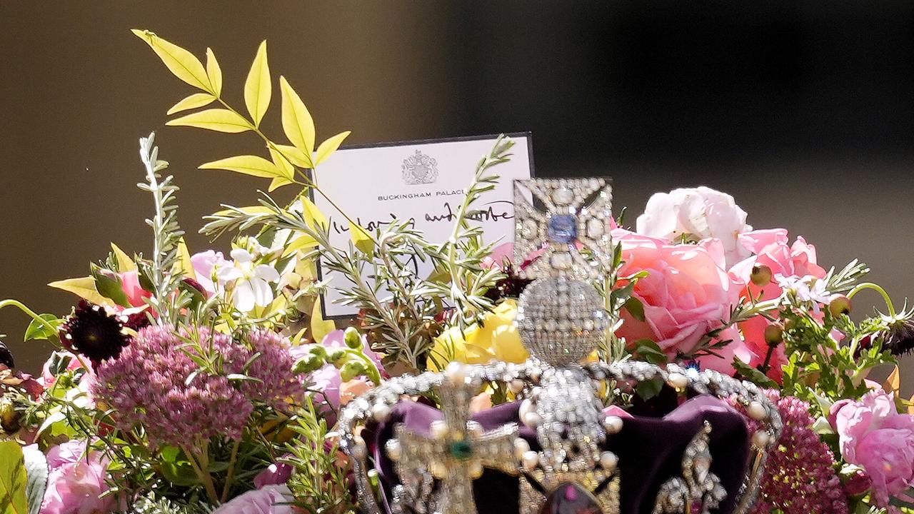 The coffin of Queen Elizabeth II with the Imperial State Crown resting on top is carried by the Bearer Party as it departs Westminster Abbey.