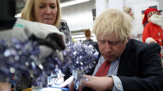 Boris Johnson uses a sewing machine at John Smedley Mill in Matlock, central England. Picture: AFP