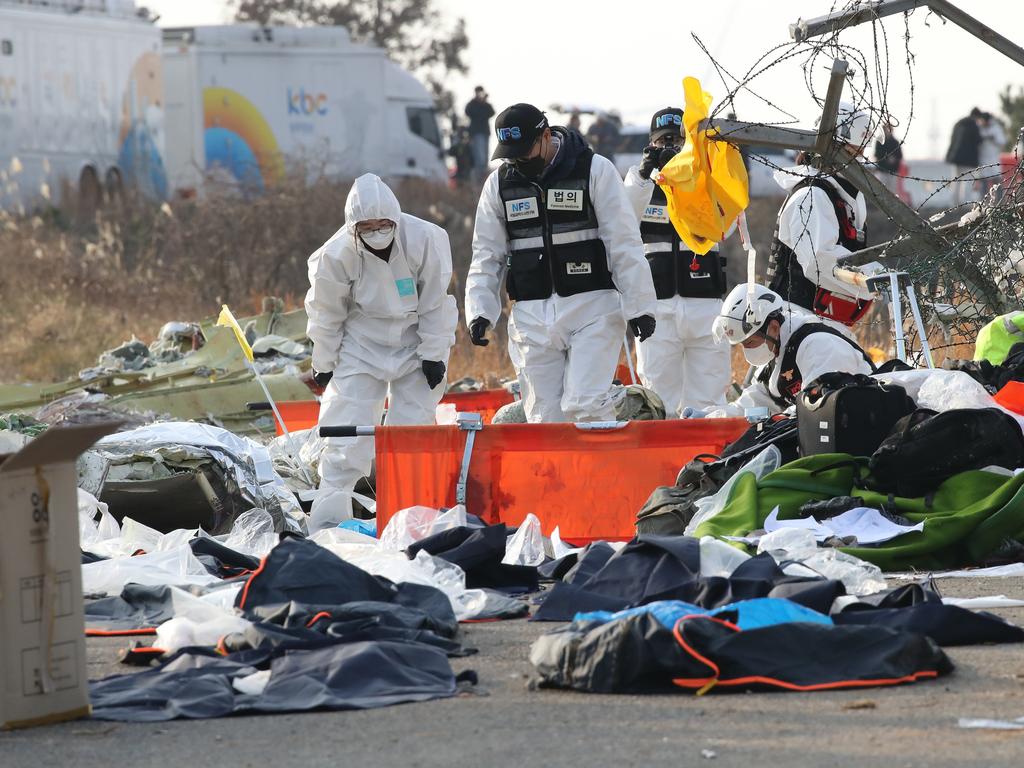 South Korean rescue team members check near the wreckage of a passenger plane at Muan International Airport. Picture: Chung Sung-Jun/Getty Images