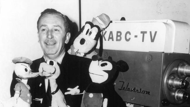 Walt Disney Walt Disney with dolls of (clockwise from upper right) Goofy, Mickey Mouse, Pluto, and Donald Duck, mid-1950s. © The Walt Disney Company