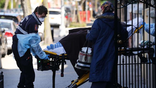 Health workers carry a patient to an ambulance in Brooklyn. Picture: AFP.