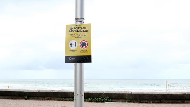 A sign showing new social distancing rules is displayed at Manly Beach on March 23, 2020. Picture: Cameron Spencer.