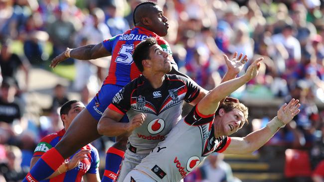 Akuila Uate flies over the top of Warriors Ben Henry and Ryan Hoffman.