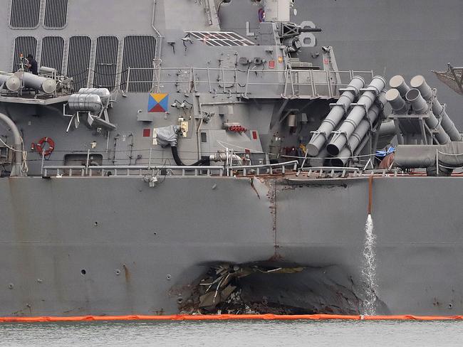 The damaged port aft hull of the USS John S. McCain is visible while docked at Singapore's Changi naval base in Singapore. The US Navy said in a statement yesterday that the Navy has relieved of duties its commander and executive officer. Picture: AP /Wong Maye-E