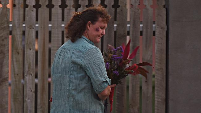A lady arrives with flowers outside the scene where three people were stabbed. Picture: Zak Simmonds
