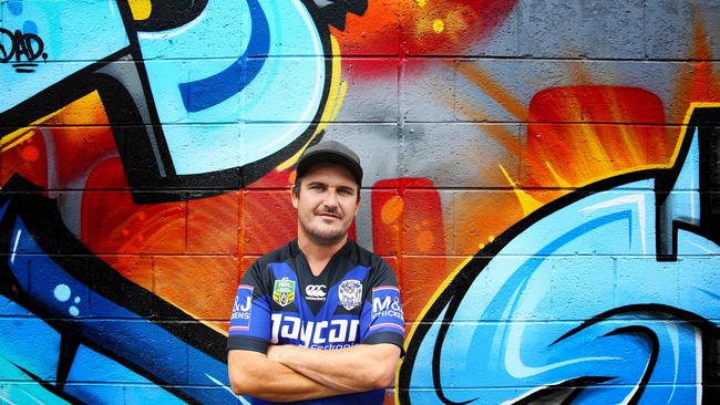 Artist Jay Router with one of the murals in Lilian Lane, Belmore. Picture: Angelo Velardo