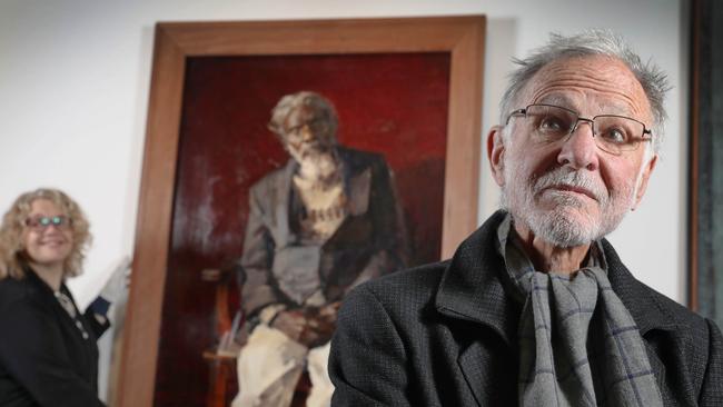 Artist Robert Hannaford in front of his 1995 portrait of Jarinyanu David Downs, being hung by exhibition curator, Natalie Wilson, 2022. Picture Dean Martin