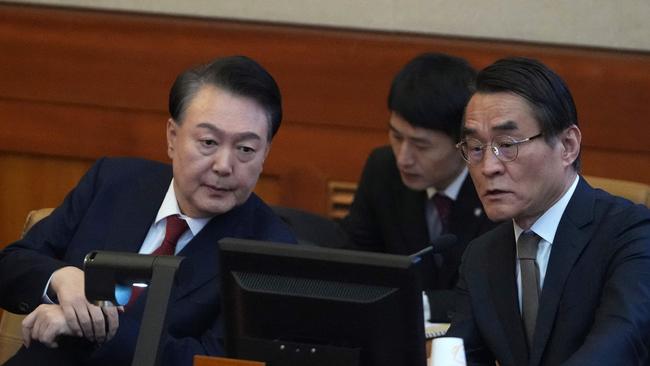 South Korea's impeached President Yoon Suk Yeol, left, talks to one of his lawyers in the Constitutional Court in Seoul on Tuesday. Picture: AFP