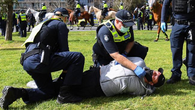 Police arrest a protester at the Albert Park Lake rally in Melbourne on Saturday. Picture: AFP