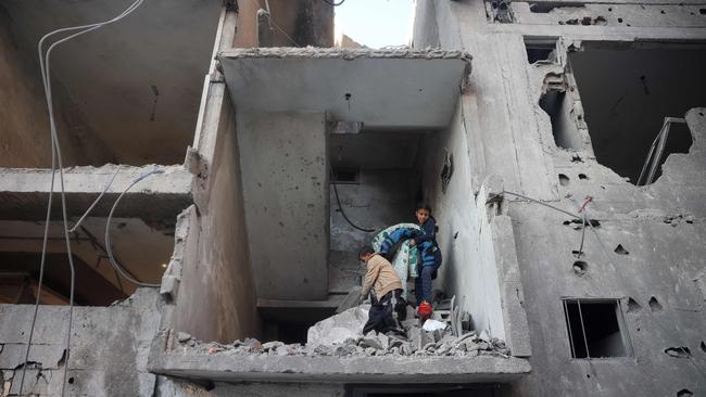 Palestinian children salvage belongings in front of a building destroyed in an Israeli air strike in Nuseirat in the central Gaza Strip on December 1, 2024. Picture: AFP