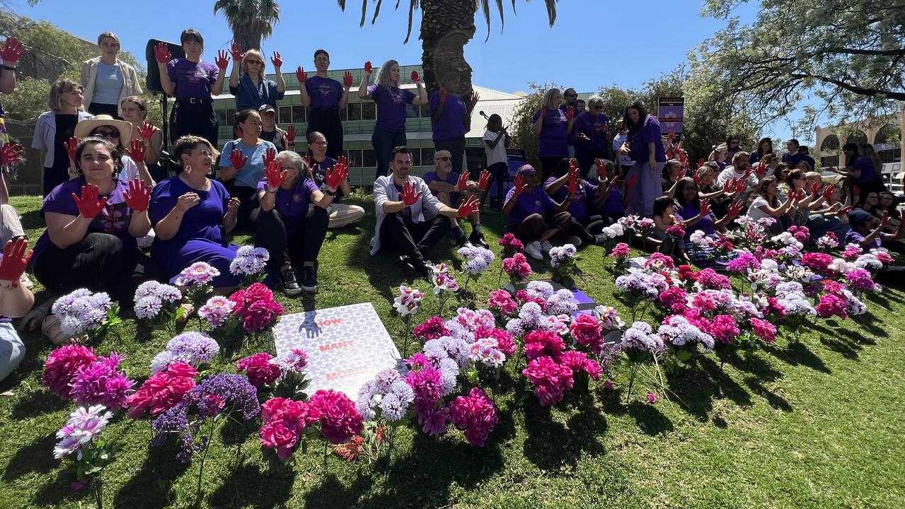 Crowds dipped their palms in red at the Day of Action against family and domestic violence rally at the Alice Springs courthouse lawns. Picture: Fia Walsh