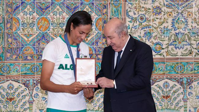 President Abdelmadjid Tebboune presents an award to Algerian Olympic boxing gold medallist Imane Khelif. Photo by ALGERIAN PRESIDENCY FACEBOOK PAGE / AFP.