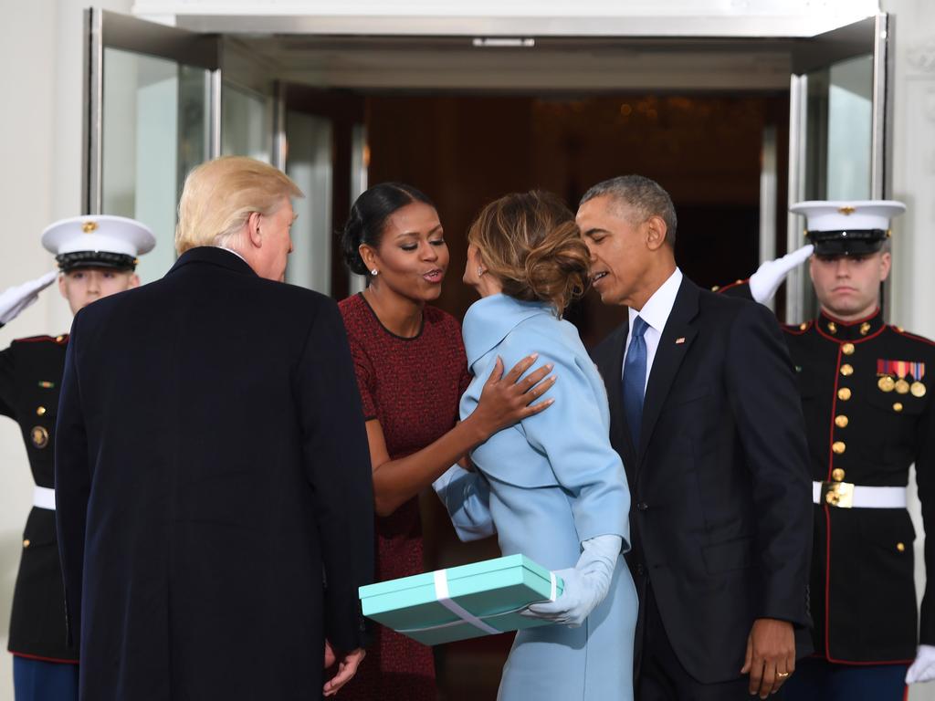 Flashback to Donald Trump’s inauguration day. Melania takes Michelle Obama by surprise when she produces a Tiffany box. The gents looks on as the ladies share a welcome kiss. Picture: AFP