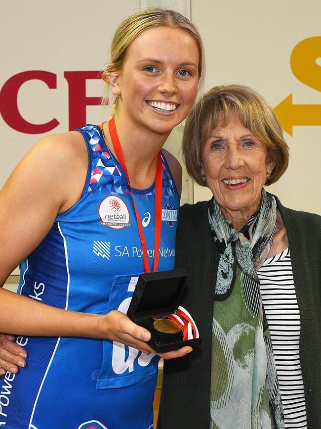 Sam Simons, accompanied by SA netball legend Marg Angove, holds the Marg Angove Medal, awarded to her for her Grand Final MVP performance. Picture: Supplied, Netball SA