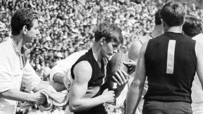 Royce Hart is dazed and concussed after having been sandwiched between two Sturt players in the first quarter of the 1969 SANFL grand final.