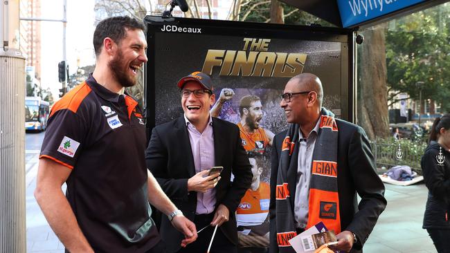 Greater Western Sydney Giants ruckman Shane Mumford surprises Mitchell Coote and Andrew Ponnambalam with Grand Final tickets at Wynyard bus stop. Picture: Brett Costello