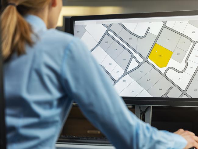 woman working with digital cadastral map land register database on computer in office