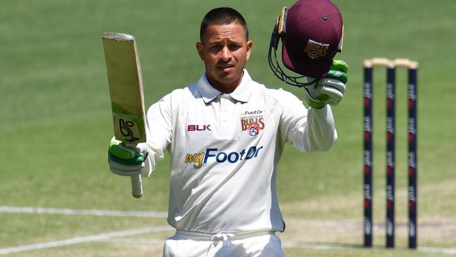 Usman Khawaja celebrates a century while playing for Queensland in the Sheffield Shield.