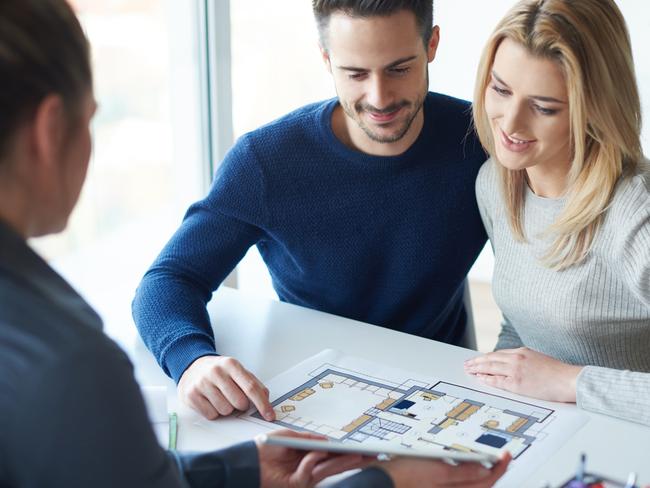 Saleswoman showing paperwork to couple