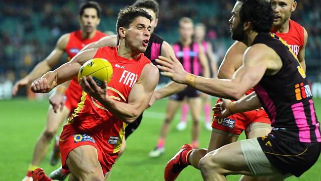 Dion Prestia handballs under pressure from Jordan Lewis.