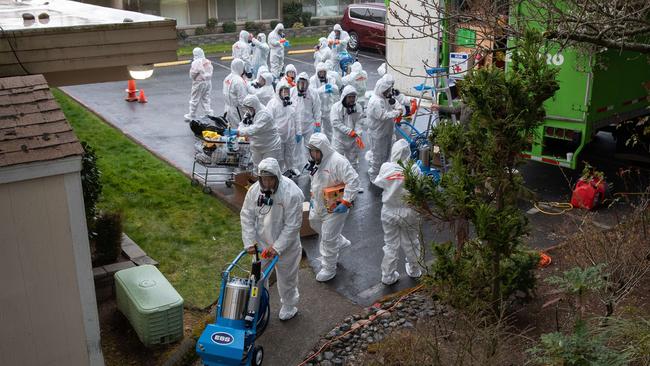 A cleaning crew wearing protective clothing enters anursing home in the Seattle suburbs.