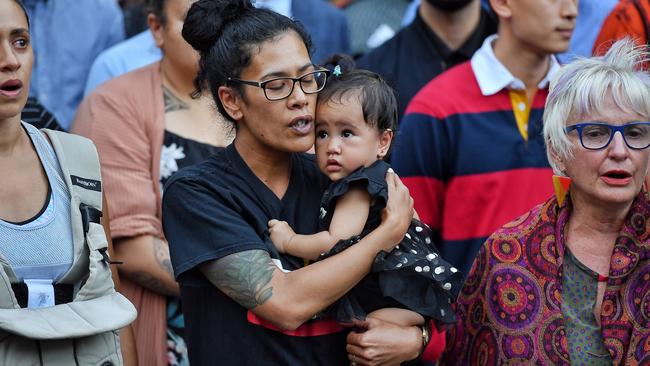 A mother and her child watch on with thousands at a vigil for victims of the Christchurch massacre in front of Melbourne’s State Library. Picture: Jason Edwards