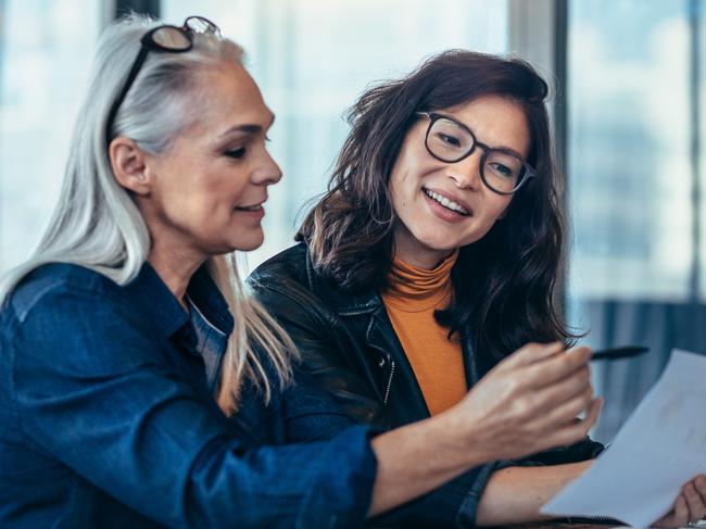 CAREERS: Performance reviews are becoming more frequent so feedback can be provided while it is still relevant. Picture: iStockTwo women analyzing documents while sitting on a table in office. Woman executives at work in office discussing some paperwork.