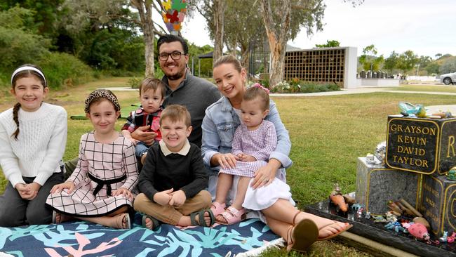 Clinton and Anastasia Taylor with Ruby, 9, Scarlet, 7, Carson, 1, Cooper, 5, and Aubrey, 2, at the headstone for Grayson at the Forever Garden at the Belgian Gardens Cemetery. Picture: Evan Morgan