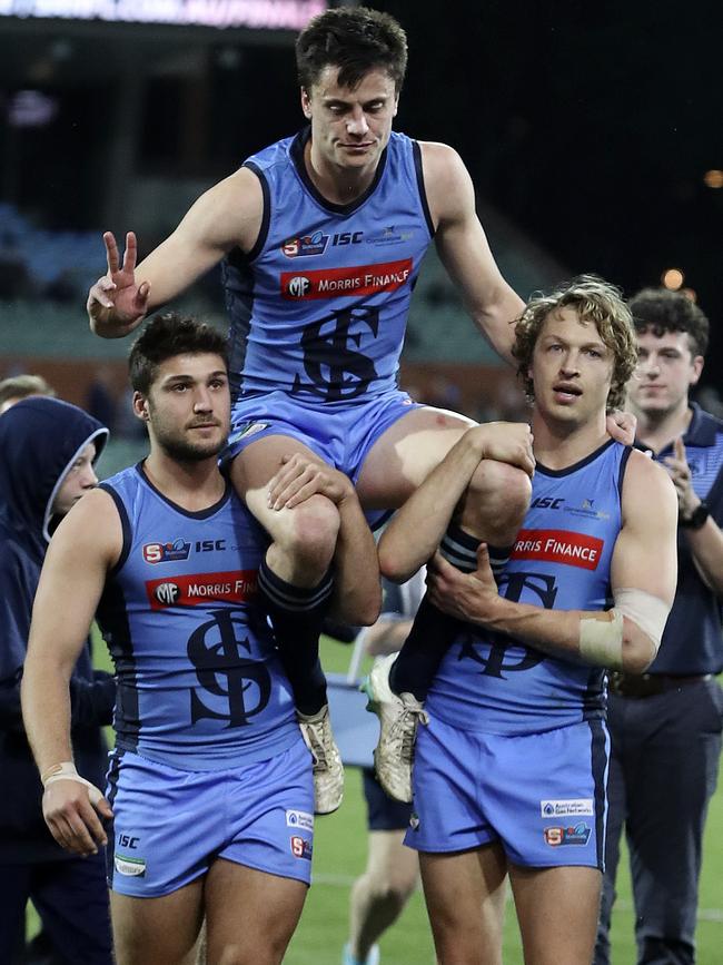 Jack Stephens gets carried off in his last game by James Battersby and Tom Harms. Picture SARAH REED