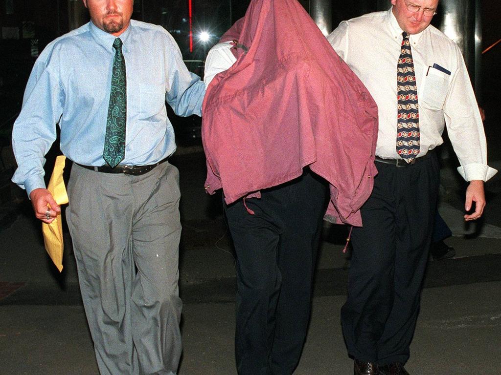 George Savvas under arrest in 1997 after he escaped prison in a blonde wig.