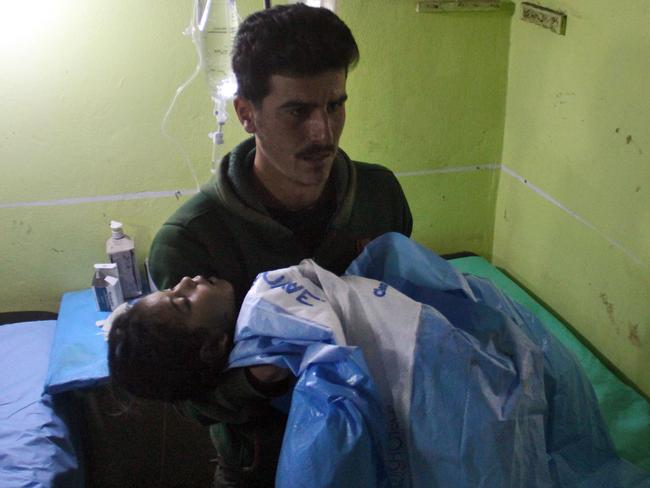 An unconscious Syrian child is cradled at a hospital in Khan Sheikhun following a suspected toxic gas attack. Picture: AFP Photo