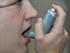 A person using an asthma inhaler