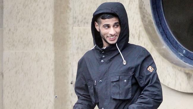 Faisal Khan, who was jailed for 13 years, is seen grinning outside court during his trial. Picture: SWNS/Snapper Media