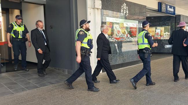 The arrest at NAB Launceston on December 7, 2022, of Extinction Rebellion protesters Graham Bailey (left), Pr Jeff McKinnon (centre) and Dr Scott Bell (right). Picture: XRNT/ Facebook