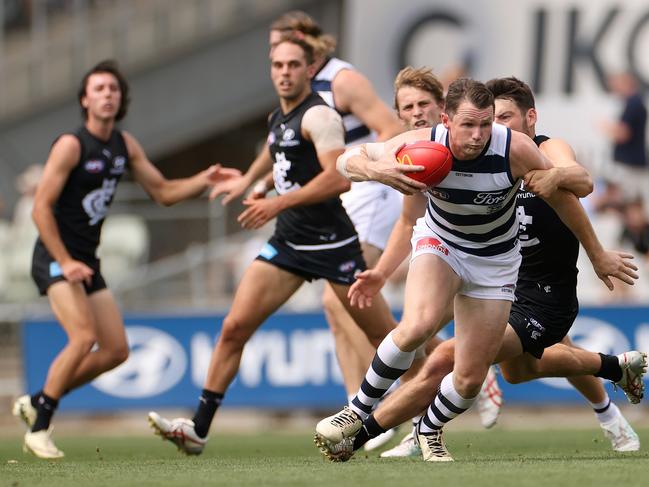 MELBOURNE, AUSTRALIA - FEBRUARY 22: Patrick Dangerfield of the Cats runs with the ball while being during an AFL practice match between Carlton Blues and Geelong Cats at Ikon Park on February 22, 2024 in Melbourne, Australia. (Photo by Kelly Defina/Getty Images)