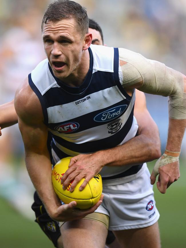 Geelong’s Joel Selwood handballs whilst being tackled against the Richmond Tigers at MCG. Picture: Quinn Rooney/Getty