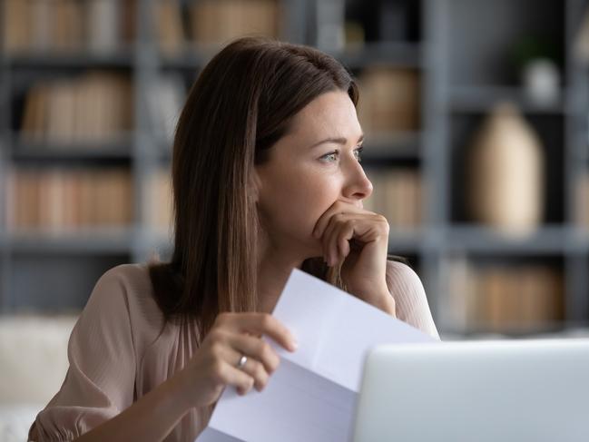 MONEY ISTOCK -  Head shot stressed young woman holding paper document, bank debt notification, thinking of financial troubles, looking away. Lost in negative thoughts depressed woman worrying about bad news notice. Picture: Istock