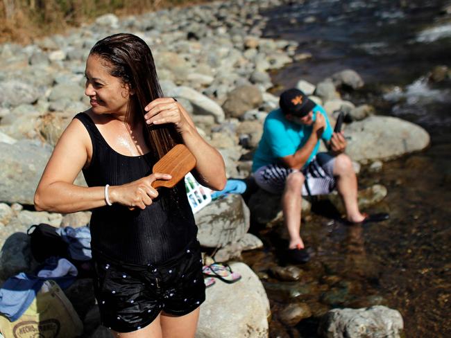 A woman combs her hair after taking a bath on the Cuyon River in the aftermath of Hurricane Maria, in Coamo, Puerto Rico on September 29, 2017. Picture: Ricardo Arduengo/AFP