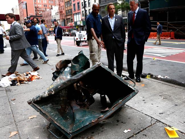 New York Mayor Bill de Blasio, second right, and New York Governor Andrew Cuomo, third right, stand in front of a mangled dumpster at the site of the Chelsea explosion. Picture: Justin Lane