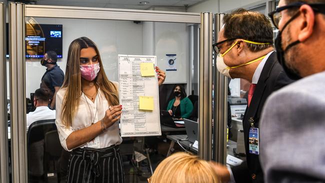 Electoral workers inspect a ballot during the vote-by-mail ballot scanning process at the Miami-Dade County Election Department in Florida. Picture: AFP