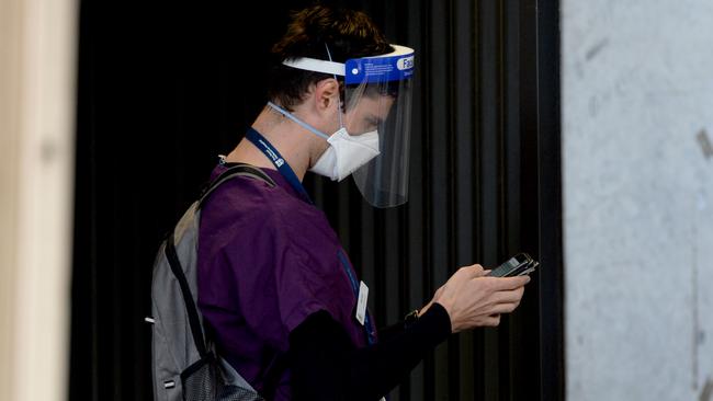 A staff member queues to enter the Royal Melbourne Hospital as it deals with a large COVID cluster. Picture: NCA NewsWire / Andrew Henshaw